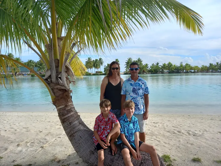 Family photo of woman, man and two children in a tropical island setting